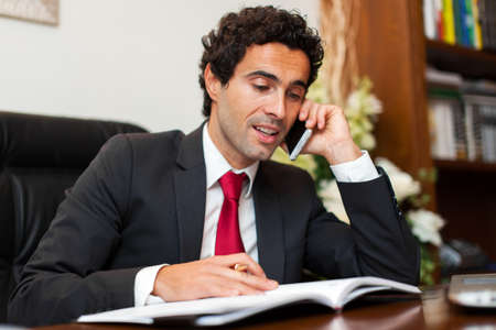 Lawyer reading a book and talking at the phoneの写真素材