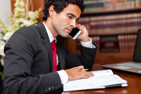 Lawyer reading a book and talking at the phoneの写真素材