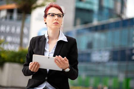 Smiling businesswoman using a digital tablet outdoorの写真素材