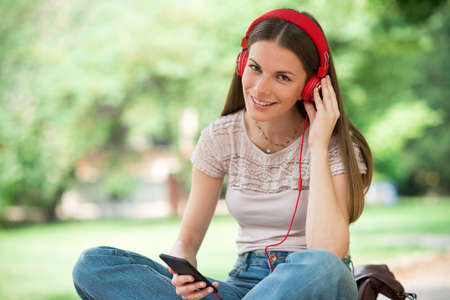 Smiling teenager listening music from phoneの写真素材