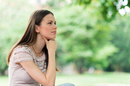 Portrait of a female student studying in a park in front of the schoolの写真素材
