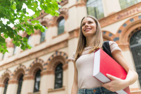 Portrait of a smiling student in front of her universityの写真素材