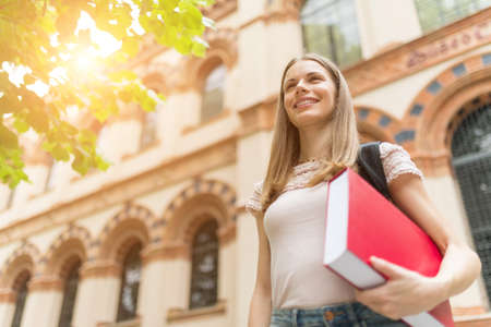 Portrait of a smiling student in front of her universityの写真素材