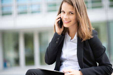 Young business woman talking on her mobile cell phoneの写真素材