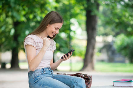 Very happy woman looking at her mobile phoneの写真素材