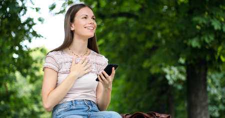 Very happy woman reading good news via her smartphoneの写真素材