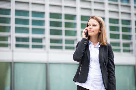 Young business woman talking on her mobile cell phoneの写真素材