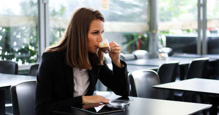 Beautiful woman having a coffee in a cafeの写真素材