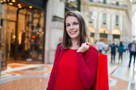 Smiling woman shopping before Christmas in a cityの写真素材