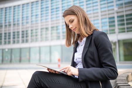 Portrait of a young woman using a tablet out of her officeの写真素材