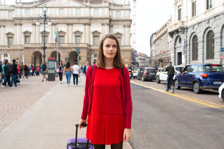 Young woman walking with her trolley in a city streetの写真素材