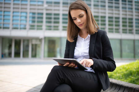 Portrait of a young woman using a tablet in front of her officeの写真素材