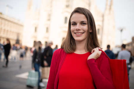Smiling young woman shopping in a big cityの写真素材