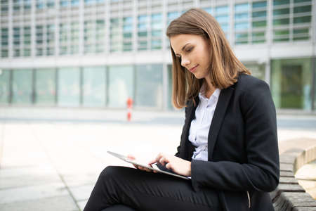 Portrait of a young woman using a tablet in front of her officeの写真素材