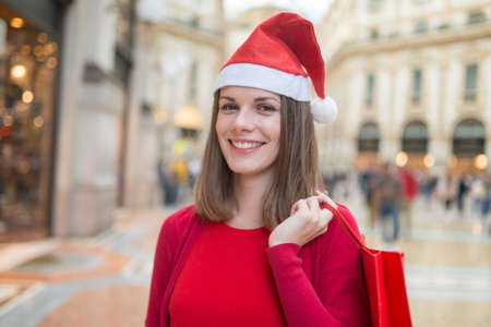 Smiling woman shopping before Christmas in a cityの写真素材