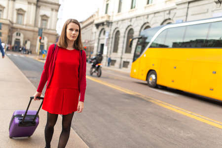 Young woman walking with her trolley in a city streetの写真素材
