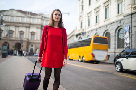 Woman walking with her trolley in a big cityの写真素材
