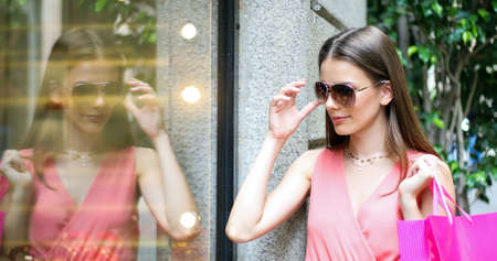 Beautiful young woman checking a store outdoor in a modern city settingの写真素材