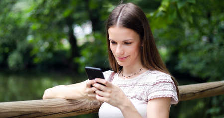 Young woman using her smartphone in a parkの写真素材