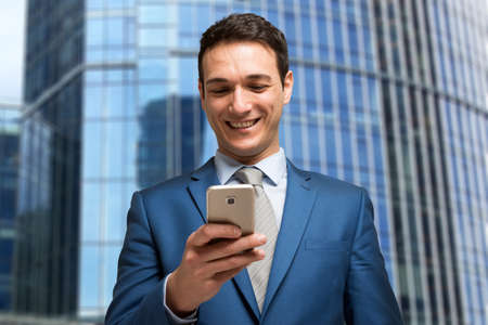 Portrait of a businessman using his mobile phoneの写真素材