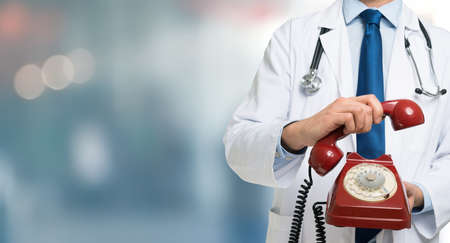 Doctor holding a vintage phone, large copy-spaceの写真素材