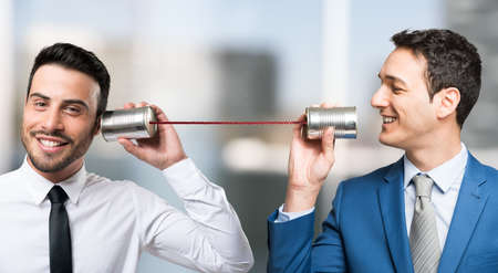 Men talking on tin can phoneの写真素材