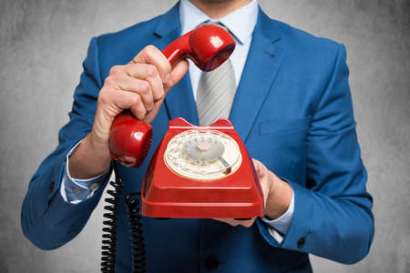Businessman holding a vintage phoneの写真素材