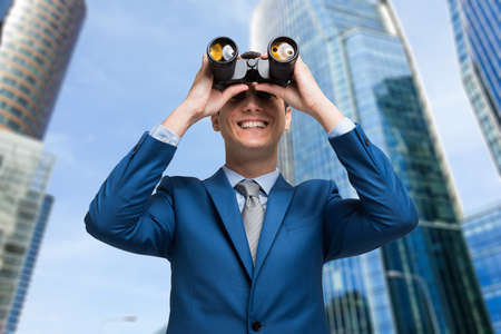 Businessman watching through binocularsの写真素材