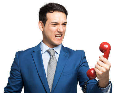 Angry businessman shouting on the phoneの写真素材