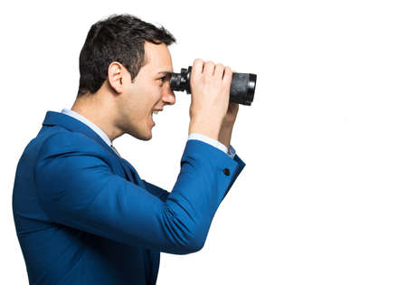 Businessman looking through binocularsの写真素材