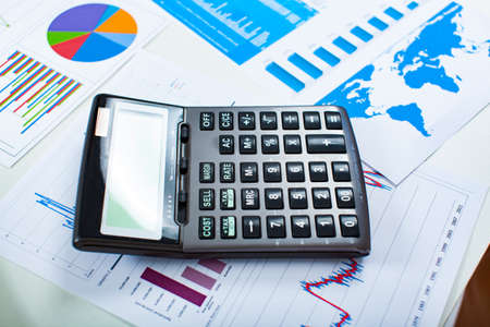 Calculator lying on many business documentsの写真素材
