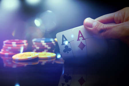 Man's hand holding two aces while playing pokerの写真素材