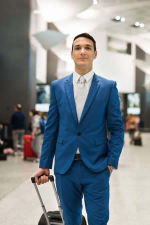 Businessman pulling a trolley, business travel conceptの写真素材