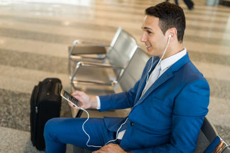 Businessman using his phone to listen musicの写真素材