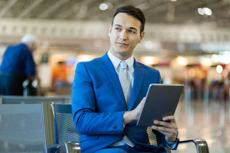 Businessman using electronic tablet in an airportの写真素材