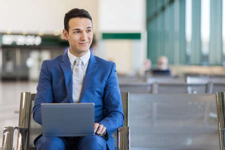 Young businessman working with his laptop in an airportの写真素材