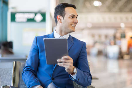 Businessman using electronic tablet in an airportの写真素材