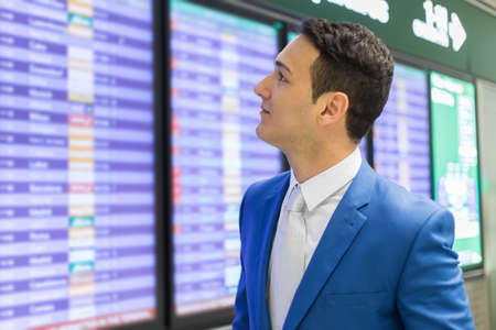 Businessman checking time in the airport, flight delay conceptの写真素材