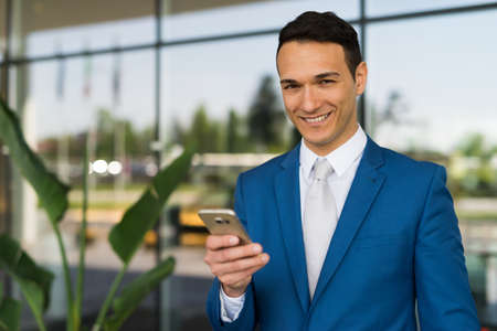 Smiling man using his smartphoneの写真素材