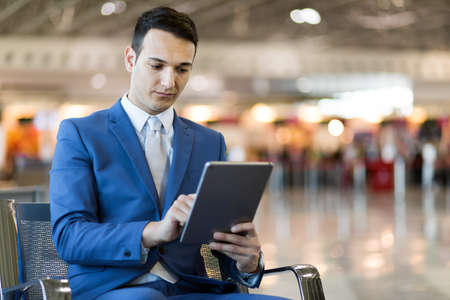 Businessman using electronic tablet in an airportの写真素材