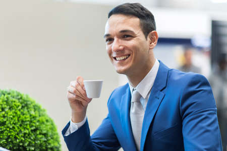 Portrait of a businessman drinking coffeeの写真素材