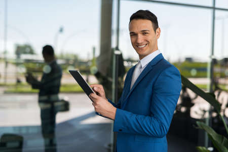 Smiling businessman using his tabletの写真素材