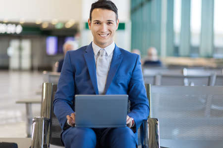 Young businessman working with his laptop in an airportの写真素材