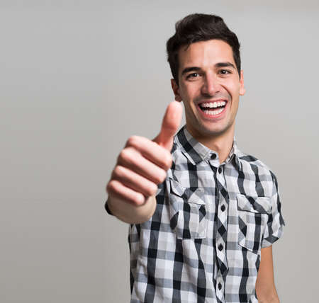 Portrait of an happy young man giving thumbs upの写真素材