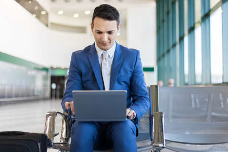 Young businessman working with his laptop in an airportの写真素材