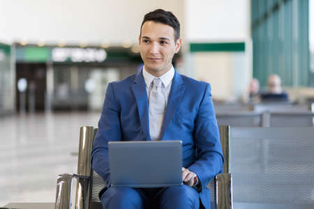 Young businessman working with his laptop in an airportの写真素材