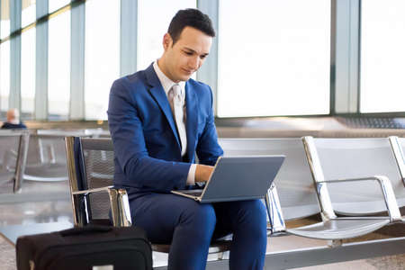 Businessman working on laptop computer at airportの写真素材
