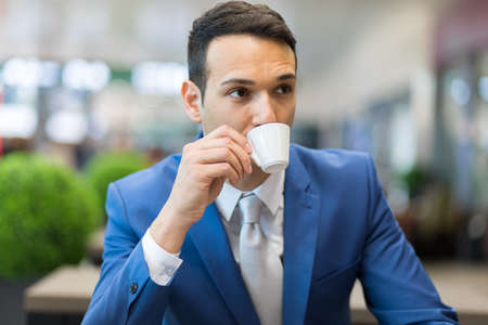 Portrait of a businessman drinking coffeeの写真素材