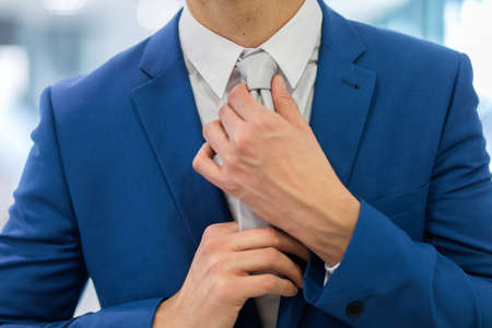 portrait of a businessman adjusting his tieの写真素材