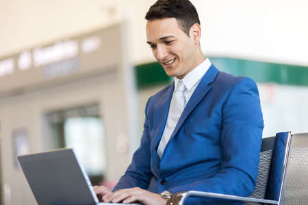 Young businessman working with his laptop in an airportの写真素材